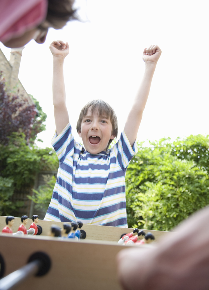 Boy celebrating playing table football Stock Photo