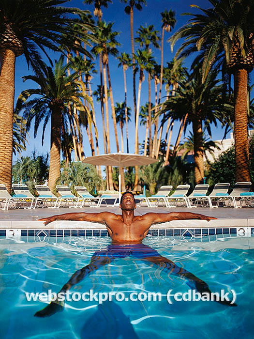 Man relaxing in swimming pool Stock Photo