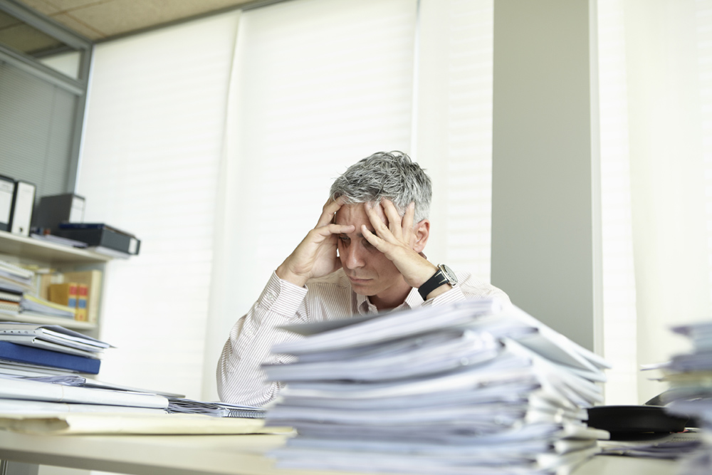 overworked Despondent man behind desk Stock Photo