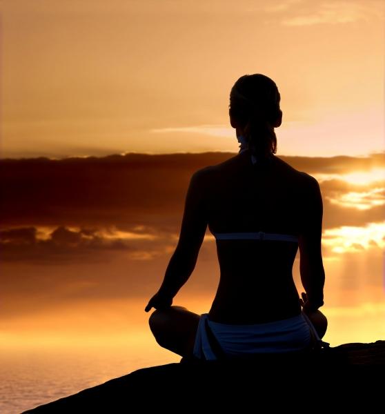 Woman making yoga at sunset beach stock photo