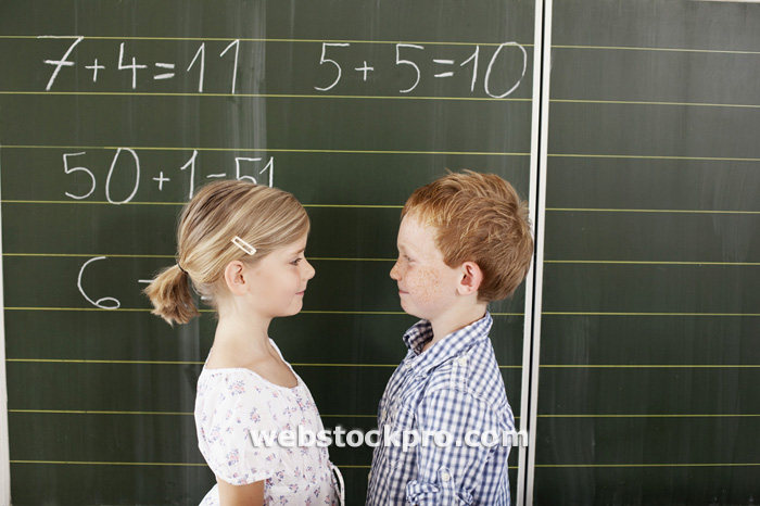 Children in front of blackboard in class Stock Photo