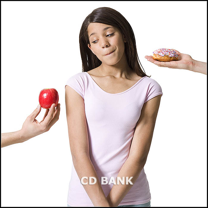 Close-up of a girl looking at an apple and donut