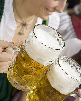 Women clinking litres of beer together (Oktoberfest, Munich) Stock Photo